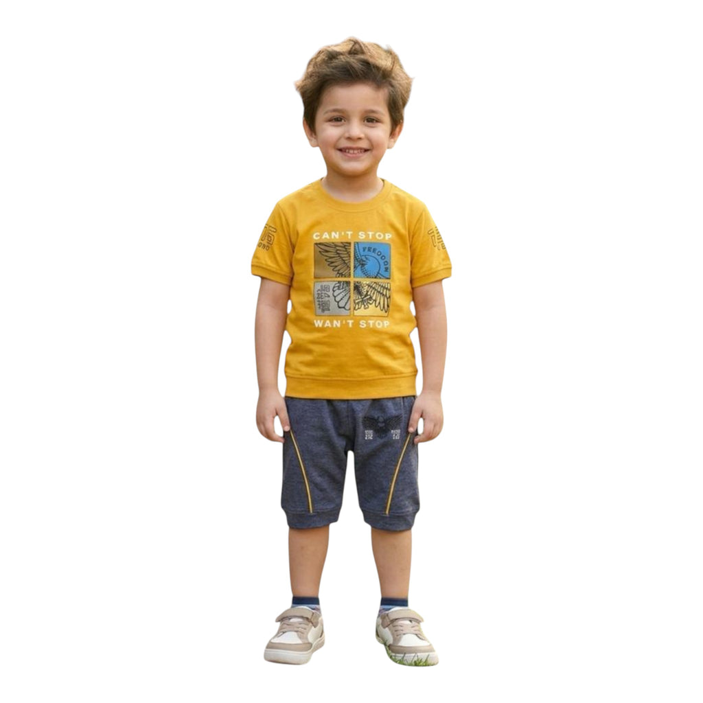 Mini & Mama boys' yellow graphic t-shirt with wings and text, paired with dark gray shorts with yellow piping.