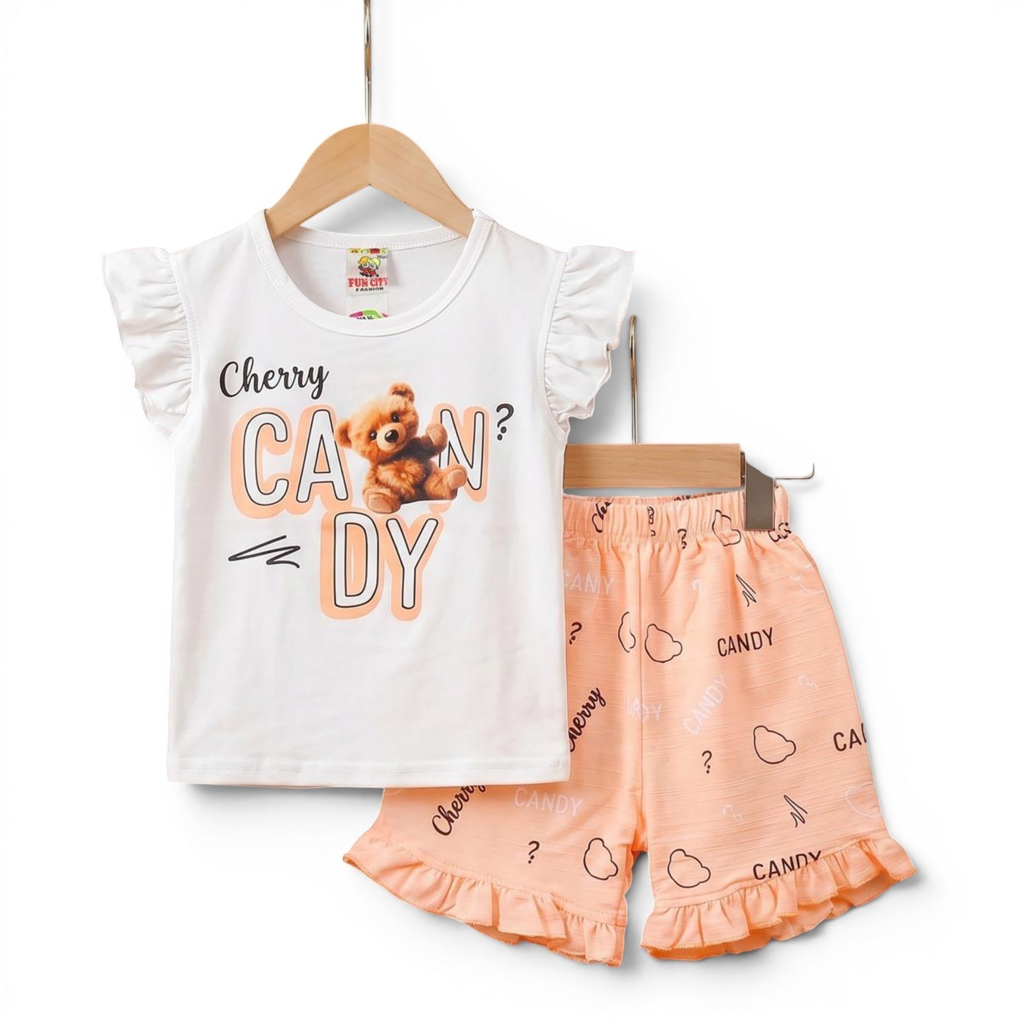 Mini & Mama Girls white t-shirt with ruffled sleeves and "Cherry Candy" teddy bear graphic, paired with peach shorts with candy print.