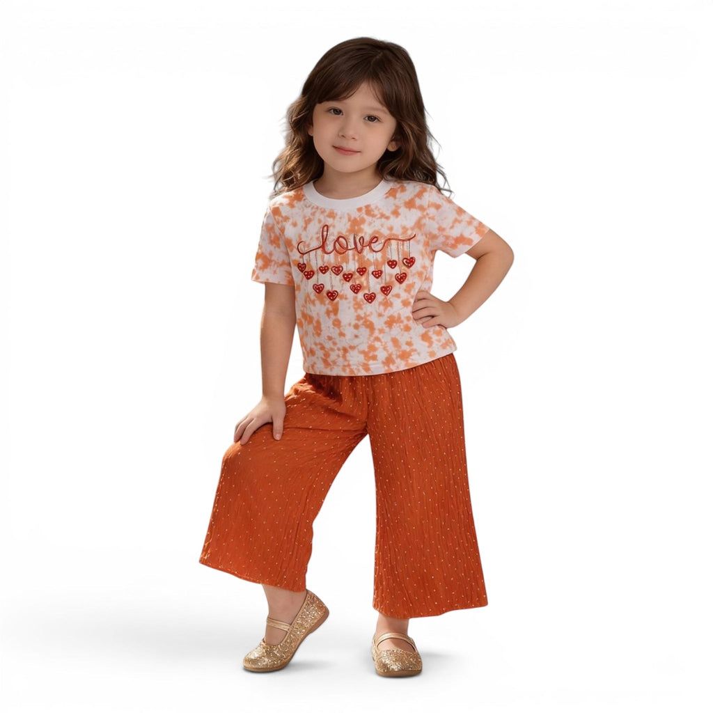 Mini & Mama Girls tie-dye t-shirt with "love" graphic and heart details, paired with orange dobby dot wide-leg pants.