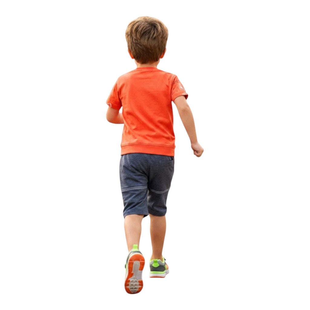 Mini & Mama Boys orange graphic t-shirt and blue denim-look shorts set. Boy running.