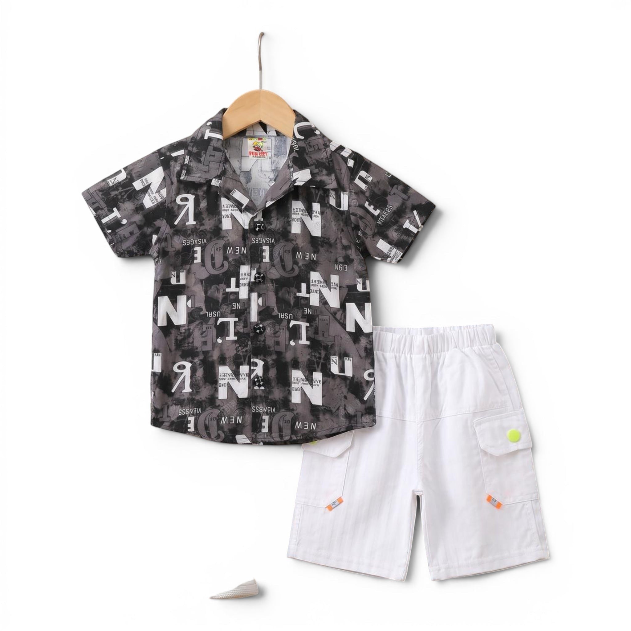 Mini & Mama Boys graphic print short sleeve shirt and white cargo shorts set. Shirt features all-over grey and black text print. Shorts have elastic waist.