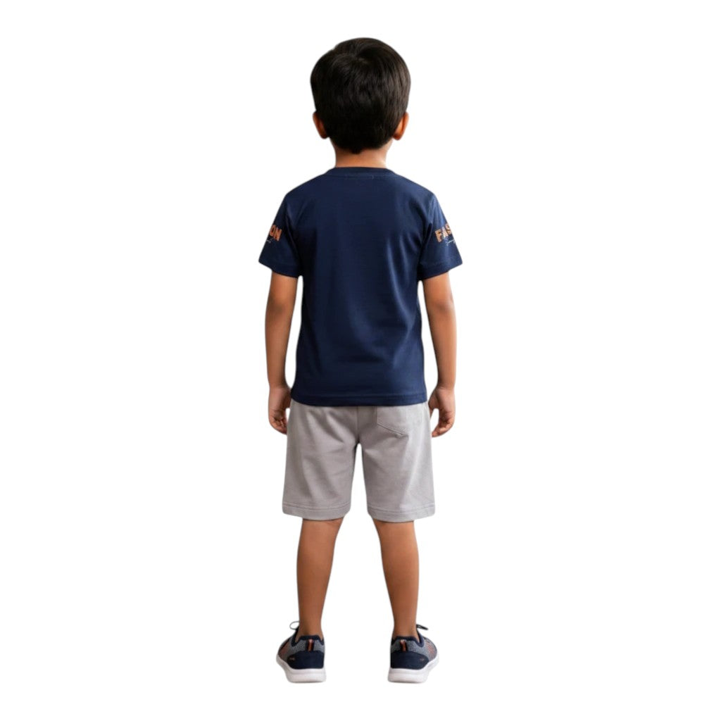 Mini & Mama Boys navy blue cotton t-shirt with "FASHION" graphic and grey shorts. Back view.