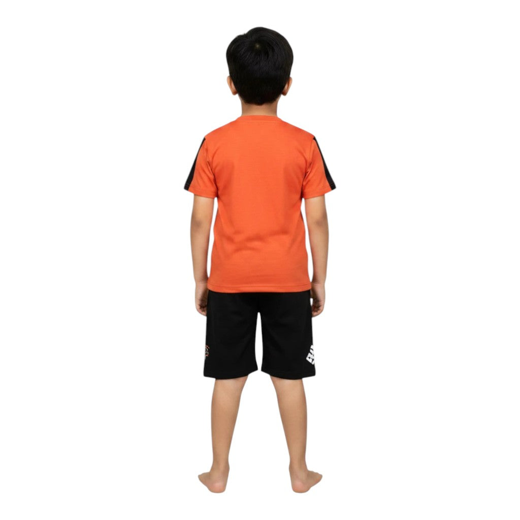 Mini & Mama boys orange graphic t-shirt with black striped sleeves and black shorts with graphic print.