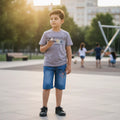 Mini & Mama boys' grey cotton blend t-shirt with graphic print and blue denim shorts set. Boy holding toy airplane.
