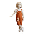 Mini & Mama orange children's overalls with teddy bear charm, cargo pockets, and adjustable straps.